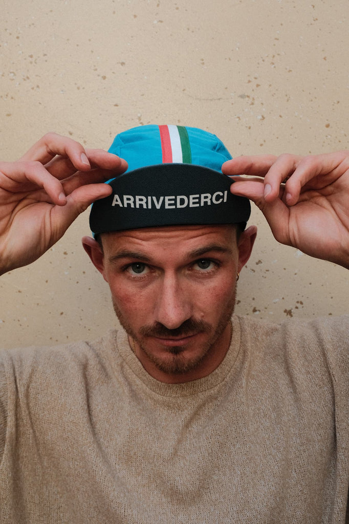 Tour of Italy 100% Cotton Cycling Cap Blue worn by a male against a wall
